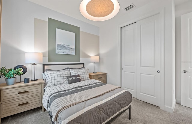 carpeted bedroom featuring visible vents and a closet