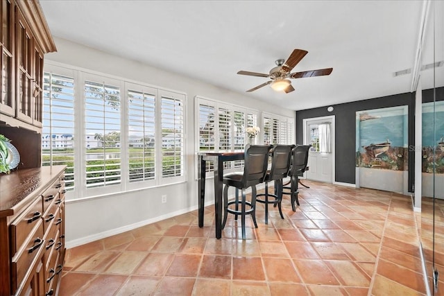 dining space featuring baseboards, a healthy amount of sunlight, and ceiling fan