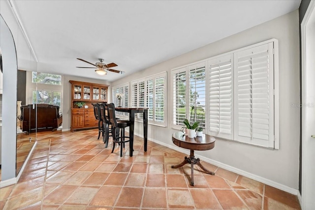 dining space featuring light tile patterned floors, baseboards, and ceiling fan