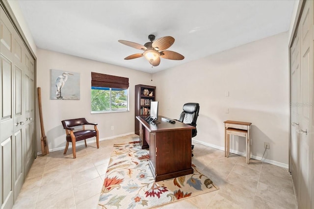 home office with light tile patterned flooring, baseboards, and a ceiling fan