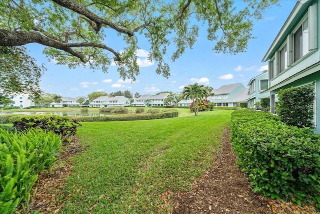 view of yard with a residential view and a water view