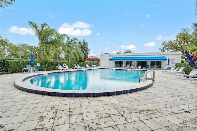 pool with fence and a patio area