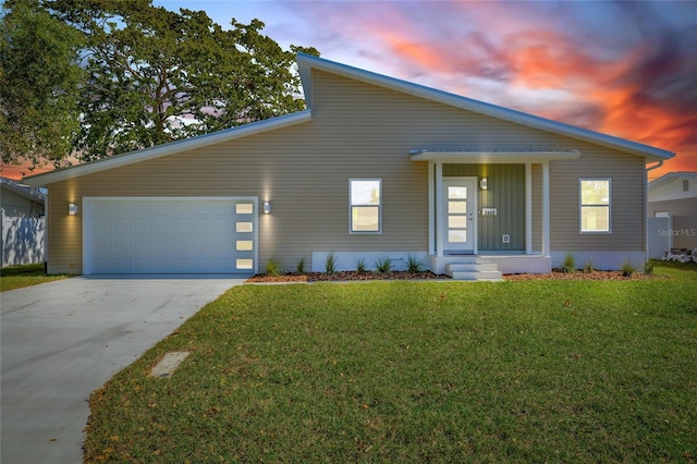 view of front of house featuring a front lawn, concrete driveway, and a garage