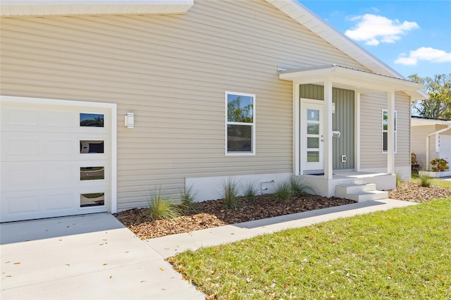 property entrance featuring an attached garage and concrete driveway