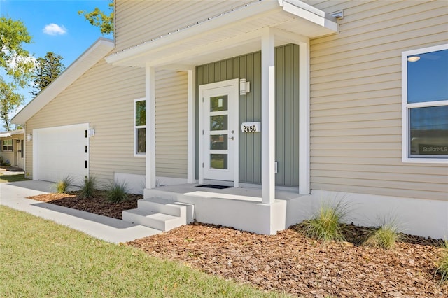 entrance to property with board and batten siding and an attached garage