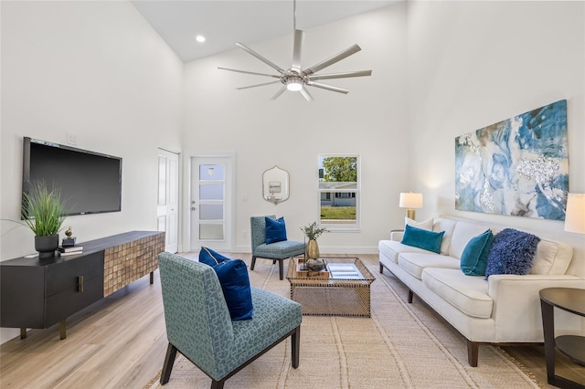 living room featuring a ceiling fan, baseboards, high vaulted ceiling, light wood-style flooring, and recessed lighting