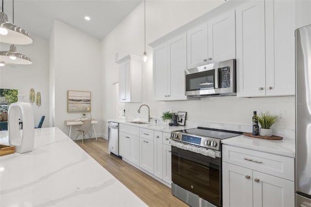 kitchen featuring a sink, appliances with stainless steel finishes, and white cabinetry