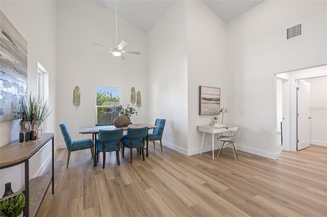 dining space featuring visible vents, light wood-style flooring, baseboards, and ceiling fan