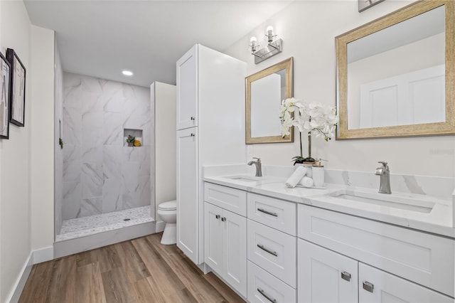 full bathroom with a sink, a marble finish shower, toilet, and double vanity