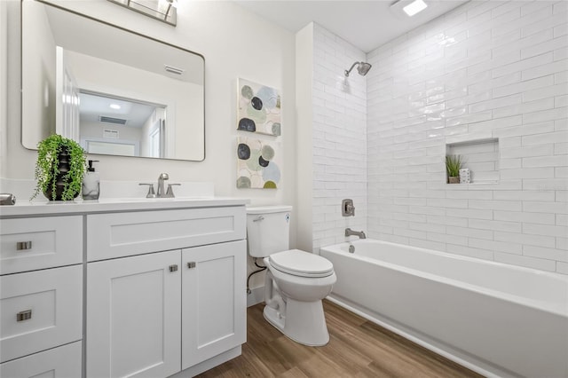 bathroom featuring vanity, wood finished floors, visible vents, shower / bath combination, and toilet