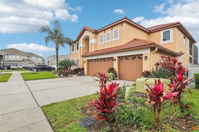 mediterranean / spanish house with a residential view, a tile roof, stucco siding, a garage, and driveway