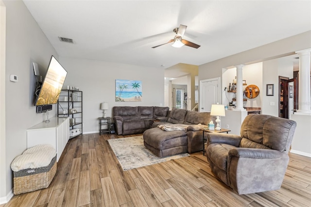 living area featuring visible vents, wood finished floors, decorative columns, baseboards, and ceiling fan