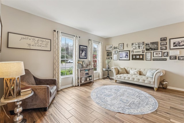 living area with baseboards and wood finished floors