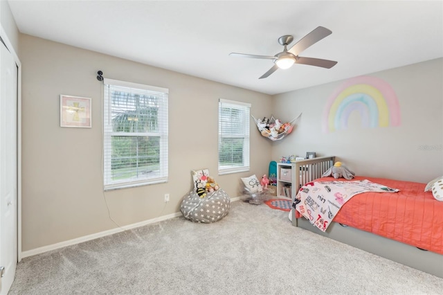 carpeted bedroom with a ceiling fan, baseboards, and a closet