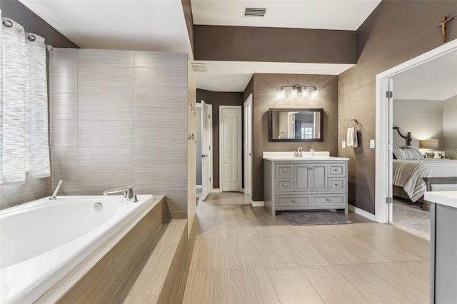 bathroom featuring visible vents, connected bathroom, baseboards, a garden tub, and vanity