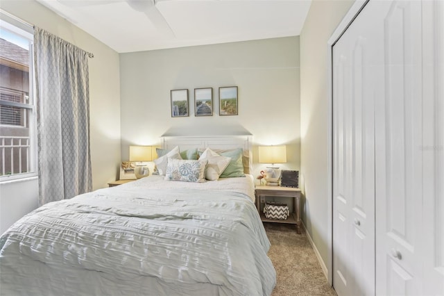 carpeted bedroom with a closet, baseboards, and ceiling fan