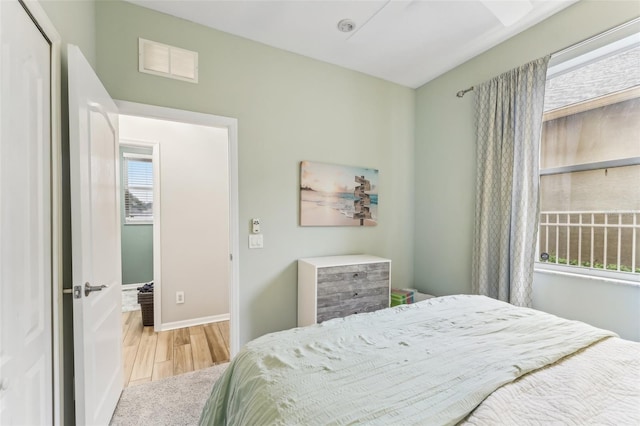 bedroom featuring wood finished floors, visible vents, and baseboards