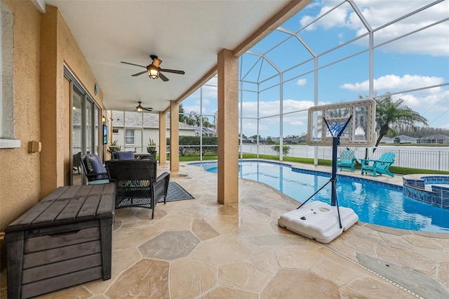 view of swimming pool with a pool with connected hot tub, ceiling fan, fence, glass enclosure, and a patio area