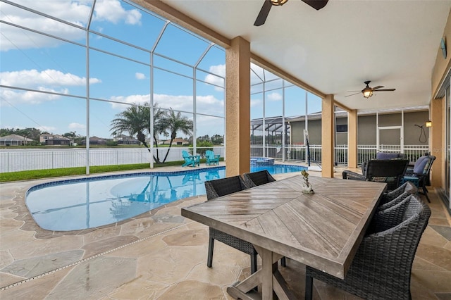 view of pool featuring glass enclosure, a patio, outdoor dining area, a pool with connected hot tub, and ceiling fan