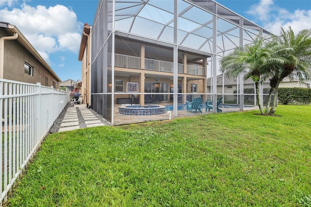 rear view of house featuring a pool with connected hot tub, glass enclosure, a fenced backyard, a yard, and a patio