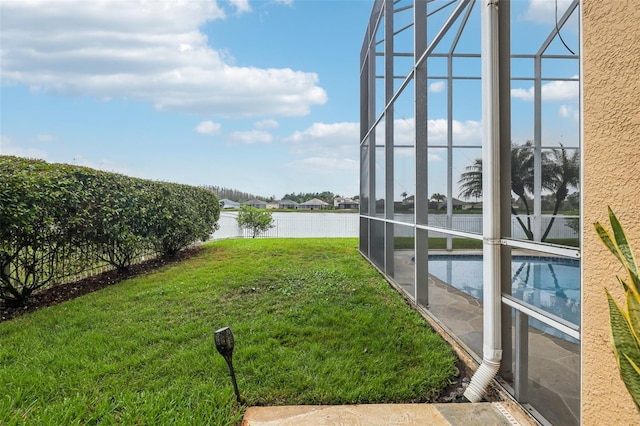 view of yard featuring glass enclosure, an outdoor pool, and a water view