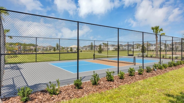 view of basketball court featuring a tennis court and fence