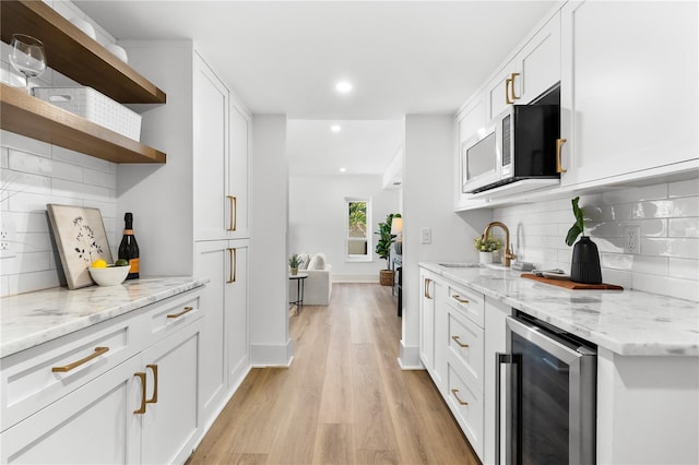 517 Belle Isle Ave, Belleair Beach, FL 33786 - kitchen with a sink, open shelves, beverage cooler, stainless steel microwave, and light wood-style floors
