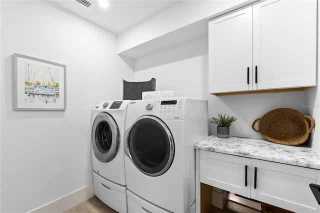 517 Belle Isle Ave, Belleair Beach, FL 33786 - laundry room with independent washer and dryer, baseboards, visible vents, cabinet space, and wood finished floors