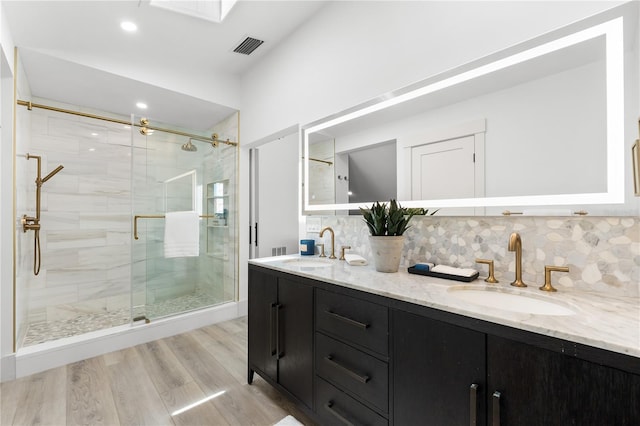 517 Belle Isle Ave, Belleair Beach, FL 33786 - full bathroom featuring a shower stall, tasteful backsplash, wood finished floors, and a sink