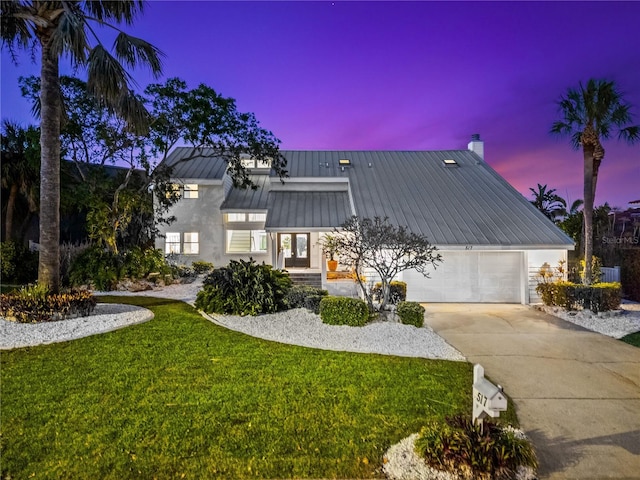 517 Belle Isle Ave, Belleair Beach, FL 33786 - view of front of home with driveway, a standing seam roof, an attached garage, metal roof, and a yard
