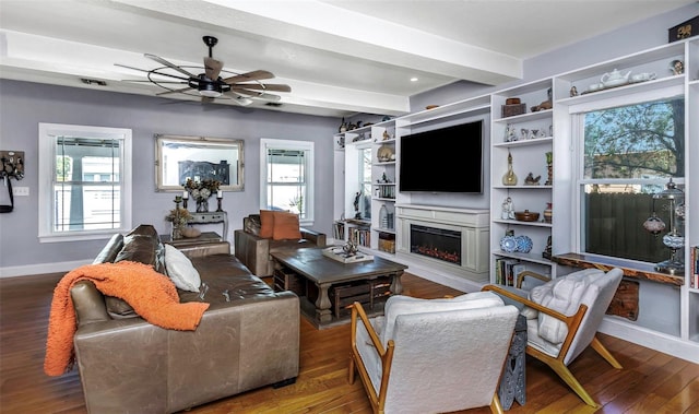 living room featuring baseboards, a lit fireplace, ceiling fan, hardwood / wood-style flooring, and beamed ceiling