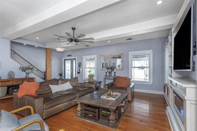 living area featuring a wealth of natural light, baseboards, and wood finished floors