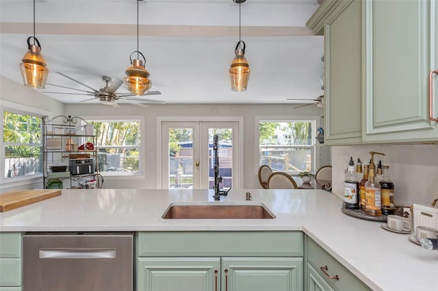 kitchen with a sink, stainless steel dishwasher, green cabinets, light countertops, and ceiling fan