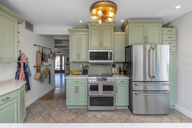 kitchen featuring visible vents, appliances with stainless steel finishes, light countertops, and green cabinetry