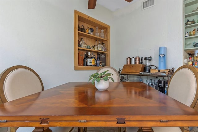 dining space with built in shelves, visible vents, and ceiling fan