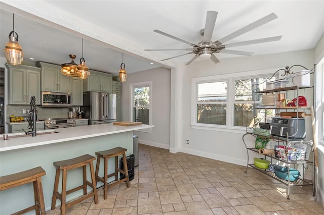 kitchen featuring tasteful backsplash, stone finish flooring, a kitchen bar, stainless steel appliances, and a ceiling fan