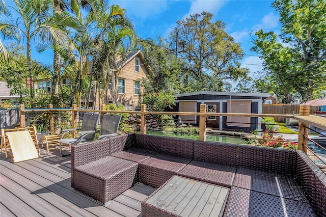 wooden terrace with an outdoor living space and an outdoor structure