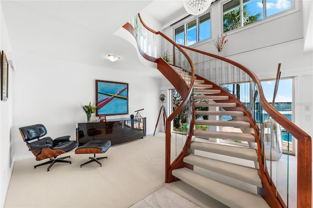 520 Belle Isle Ave, Belleair Beach, FL 33786 - stairway featuring a notable chandelier, marble finish floor, and a high ceiling