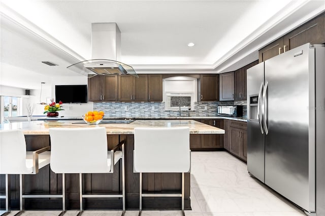 520 Belle Isle Ave, Belleair Beach, FL 33786 - kitchen featuring marble finish floor, island exhaust hood, stainless steel fridge with ice dispenser, decorative backsplash, and dark brown cabinets