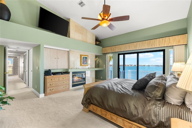 520 Belle Isle Ave, Belleair Beach, FL 33786 - bedroom with visible vents, a water view, light carpet, access to outside, and a glass covered fireplace