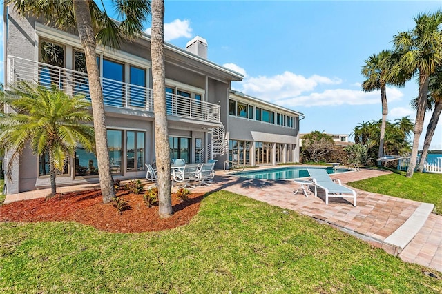 520 Belle Isle Ave, Belleair Beach, FL 33786 - rear view of property featuring a patio, a lawn, a chimney, and stucco siding