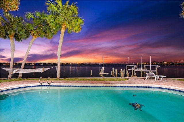 520 Belle Isle Ave, Belleair Beach, FL 33786 - pool at dusk featuring a dock, an outdoor pool, a water view, and boat lift