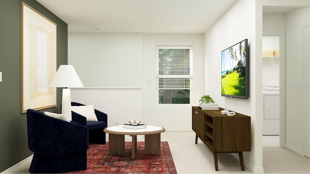 living area featuring washer / dryer, carpet flooring, and baseboards