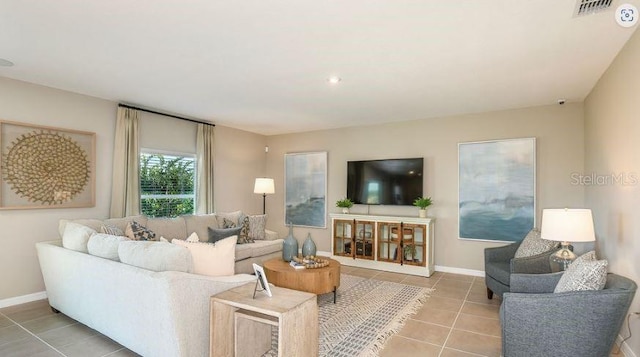 living room featuring light tile patterned flooring, baseboards, and visible vents