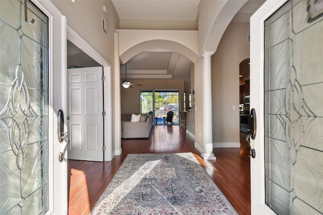 entryway with dark wood finished floors, arched walkways, ornate columns, and ceiling fan