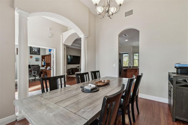 dining area featuring arched walkways, visible vents, baseboards, and dark wood-style flooring