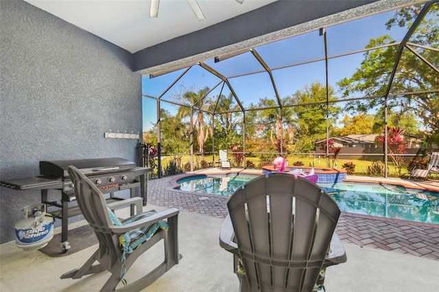 view of pool featuring glass enclosure, a patio, a ceiling fan, and a pool with connected hot tub