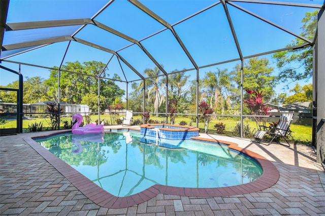 view of pool featuring glass enclosure, a patio, and a pool with connected hot tub