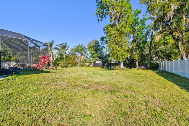 view of yard featuring glass enclosure and a fenced backyard