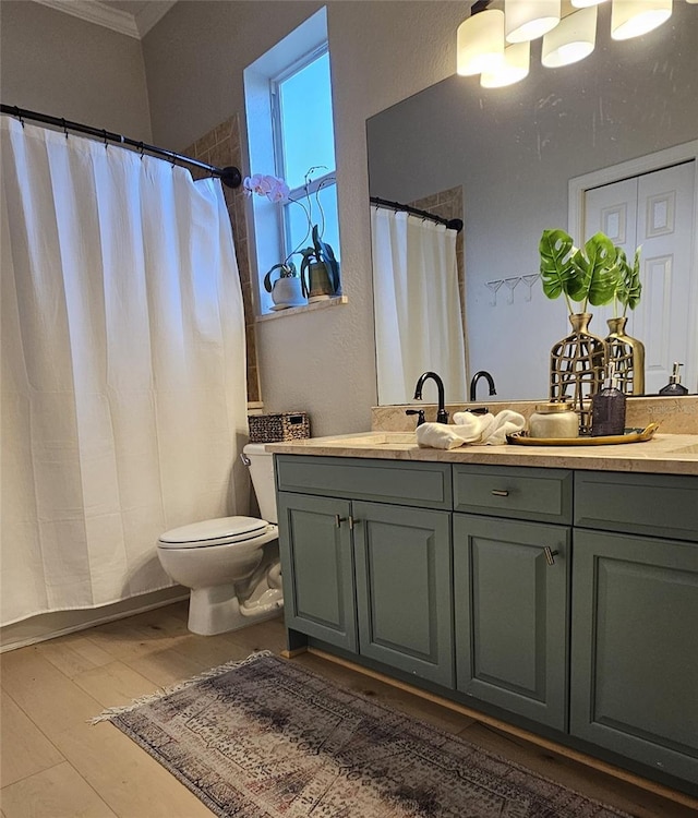 full bathroom with toilet, wood finished floors, vanity, and crown molding